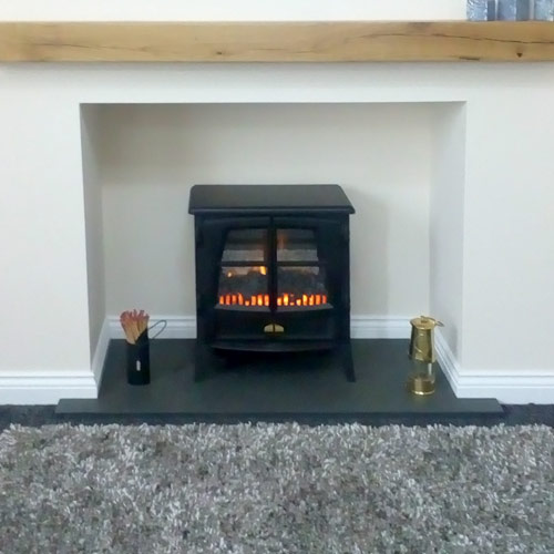 Made-to-measure T-shaped slate hearth with lit stove