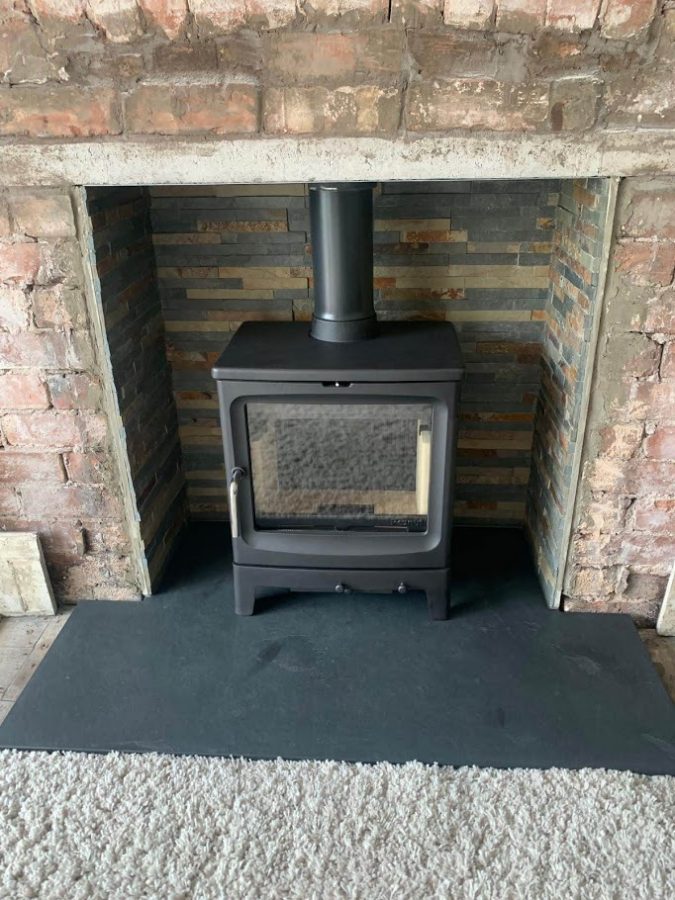 Traditional stove on one of our bespoke T-shape slate hearths