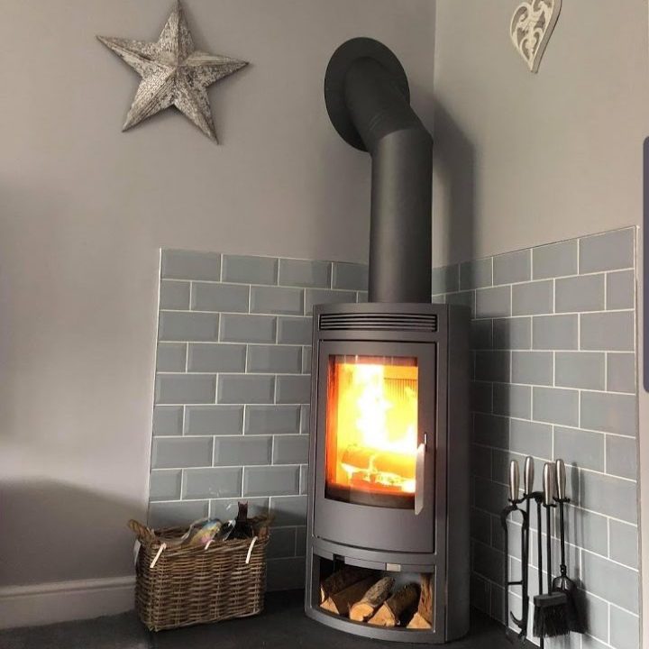 A corner stove on one of our bespoke five-sided pentagonal slate hearths