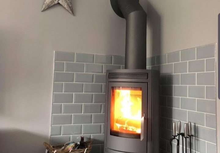 A corner stove on one of our bespoke five-sided pentagonal slate hearths