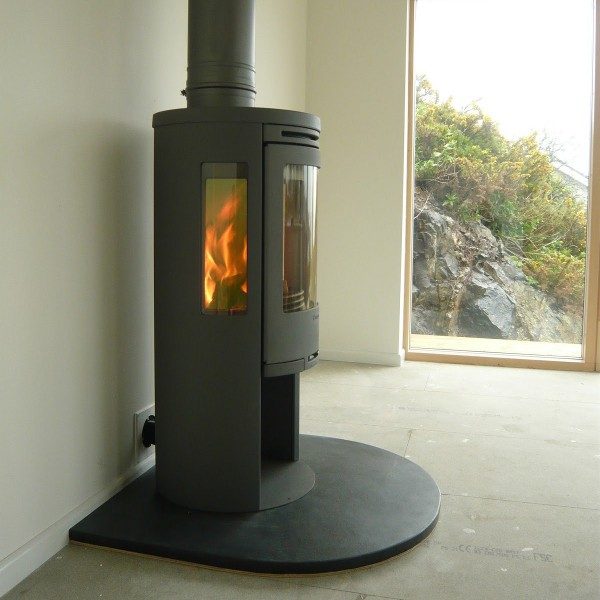 Curved front edge slate hearth with fire in a living room