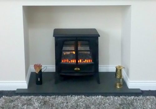 Made-to-measure T-shaped slate hearth with lit stove