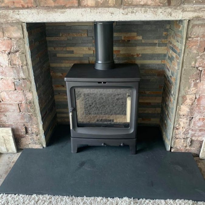 Traditional stove on one of our bespoke T-shape slate hearths